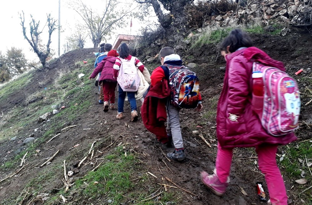 Öğrenciler çamurlu patika yolda okula gidiyor
